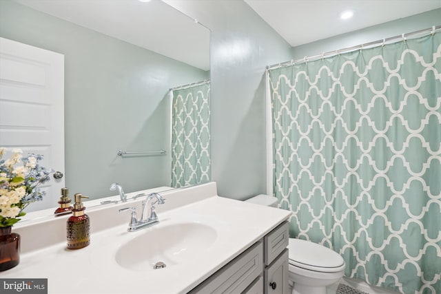 bathroom featuring toilet, a shower with shower curtain, and vanity