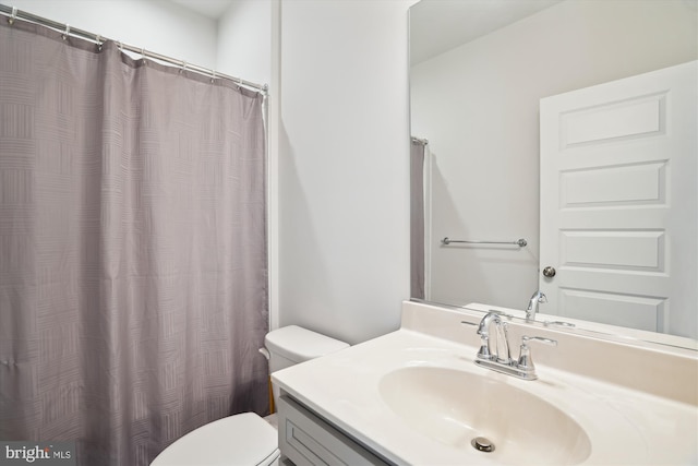 bathroom featuring curtained shower, toilet, and vanity