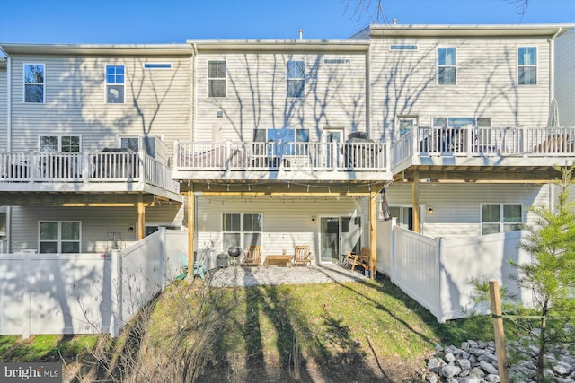 rear view of property with a lawn and a patio