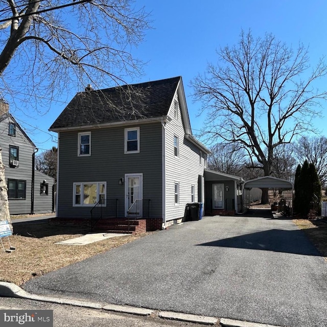 view of front of house featuring a shingled roof and aphalt driveway