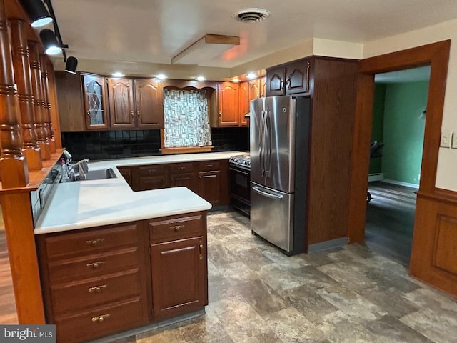 kitchen with black range with electric cooktop, a sink, visible vents, freestanding refrigerator, and decorative backsplash