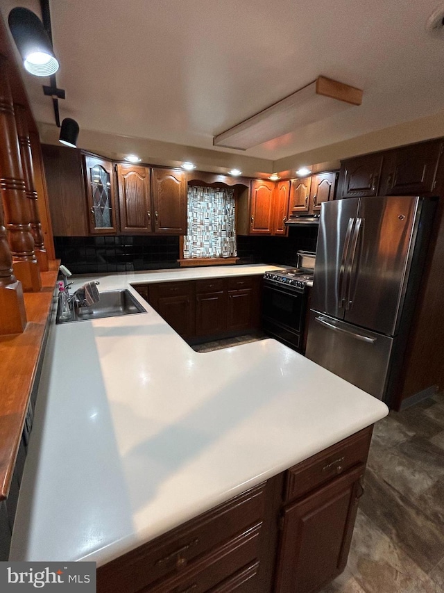 kitchen with freestanding refrigerator, light countertops, a sink, and black / electric stove