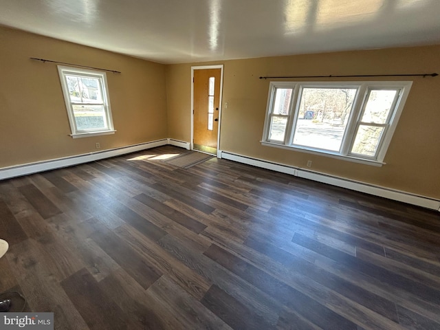 spare room with a healthy amount of sunlight, a baseboard radiator, and dark wood-style flooring