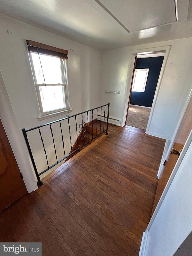 staircase featuring a baseboard radiator and hardwood / wood-style floors