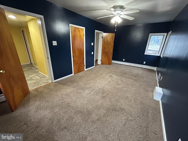 unfurnished bedroom with carpet, ceiling fan, a baseboard radiator, and baseboards