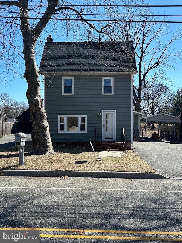 view of front of house featuring a shingled roof, a chimney, aphalt driveway, and a carport