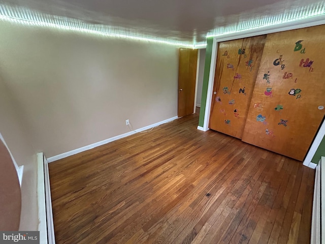 unfurnished bedroom featuring baseboards and hardwood / wood-style floors