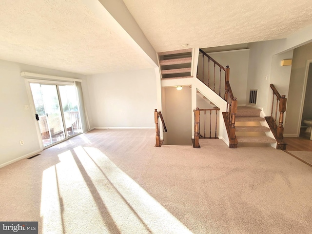 stairway with a textured ceiling and carpet