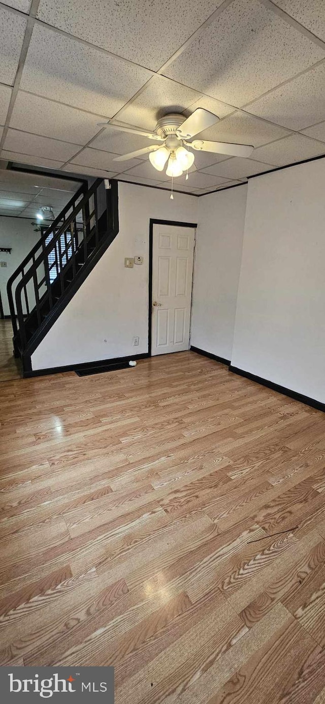 interior space featuring a paneled ceiling, ceiling fan, and light hardwood / wood-style floors