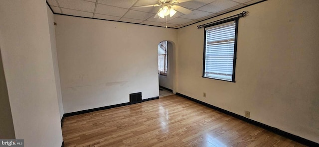 empty room featuring ceiling fan, light hardwood / wood-style flooring, and a paneled ceiling