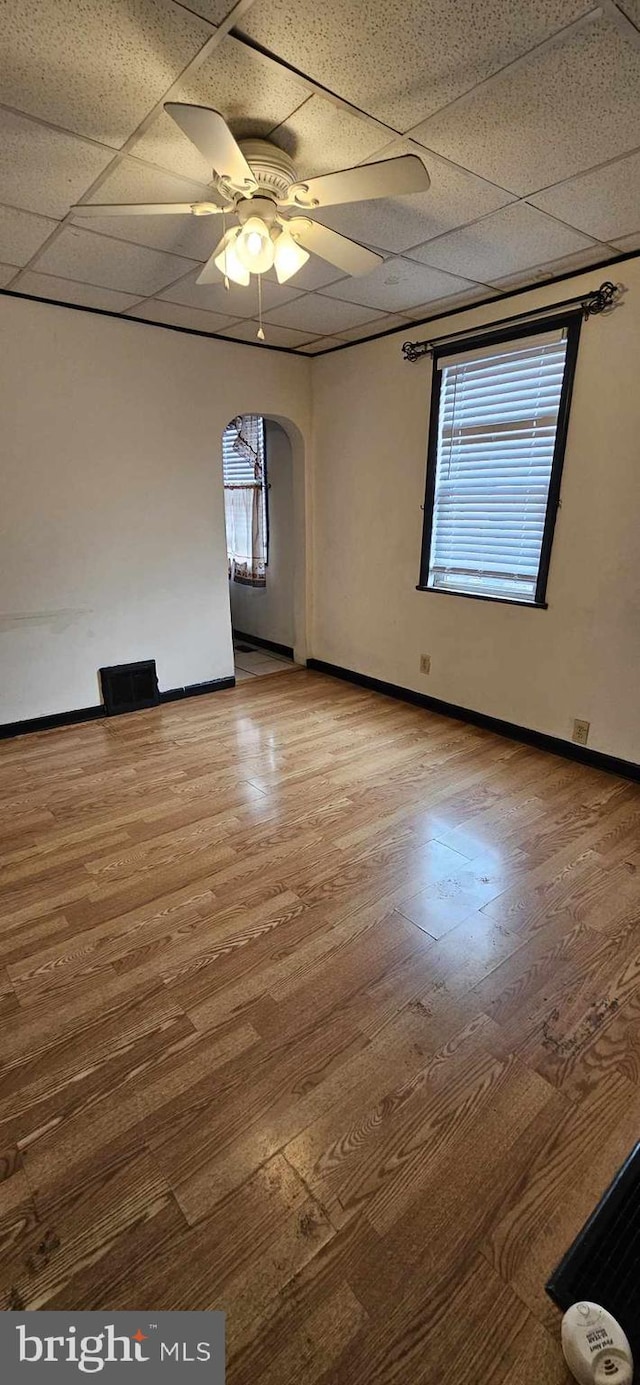 spare room featuring a paneled ceiling, hardwood / wood-style floors, and ceiling fan