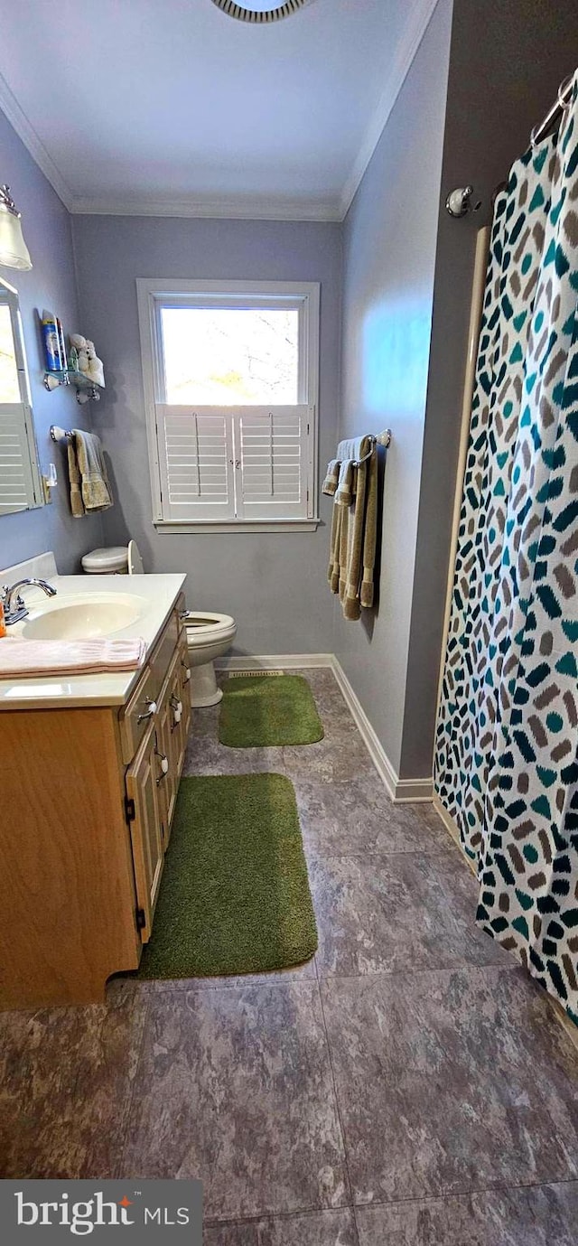 bathroom featuring toilet, vanity, baseboards, ornamental molding, and a shower with curtain