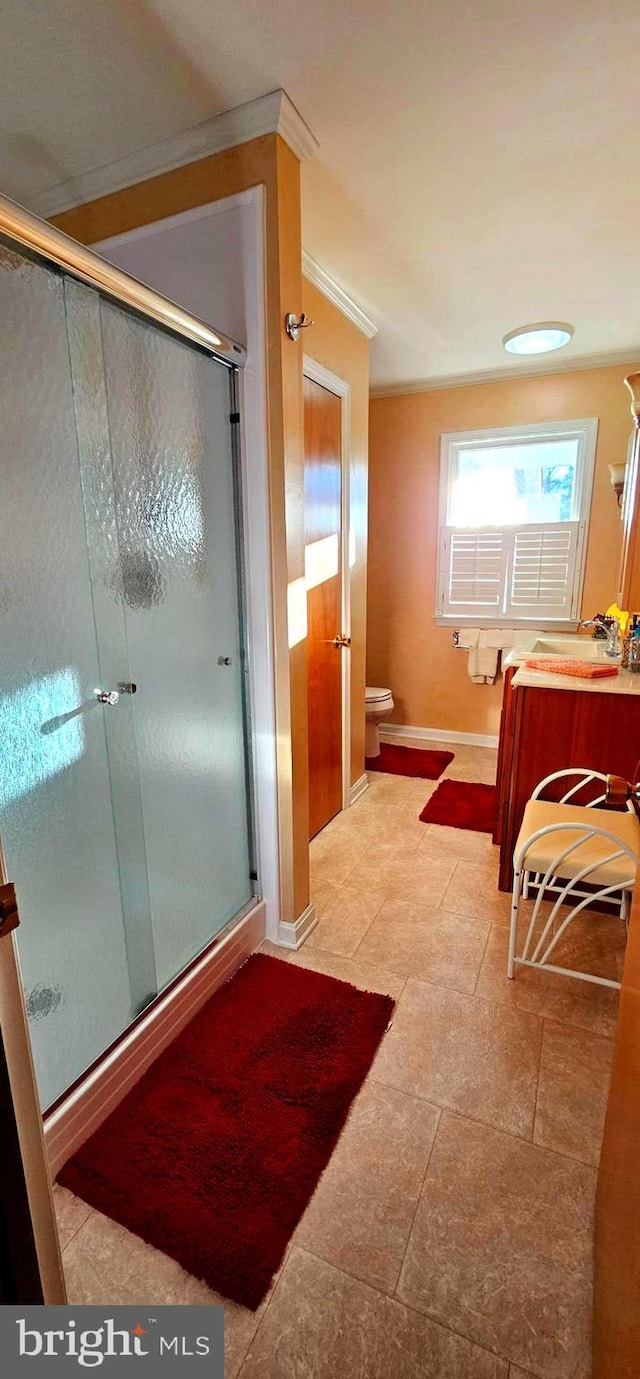 full bath featuring toilet, a stall shower, baseboards, and vanity