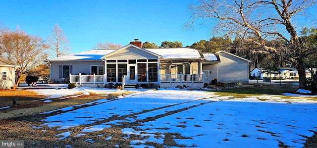 view of front of house with a sunroom and a chimney