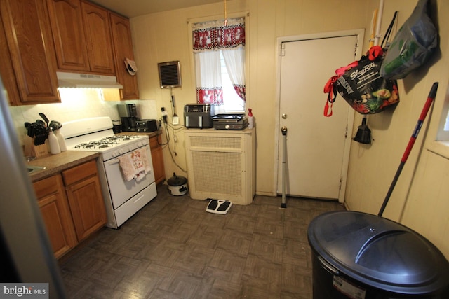 kitchen featuring white gas range oven and dark parquet floors