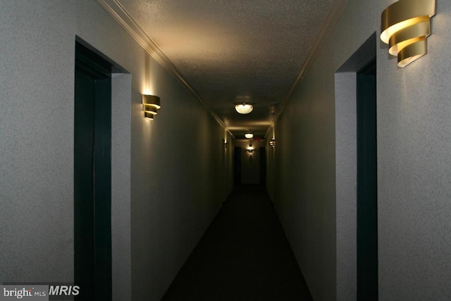 corridor with a textured ceiling and crown molding