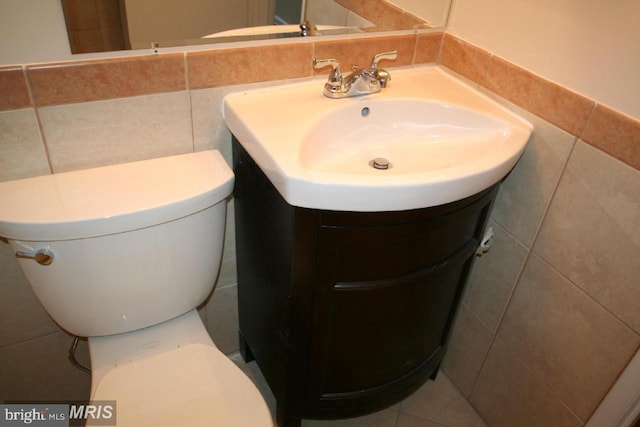 bathroom with tile walls, toilet, and vanity