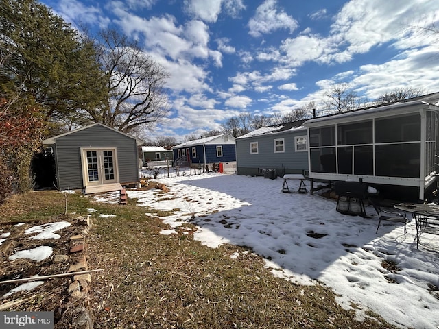 yard covered in snow featuring a sunroom