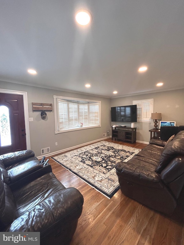 living room with wood-type flooring and ornamental molding