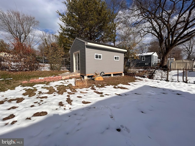 snow covered property featuring an outbuilding