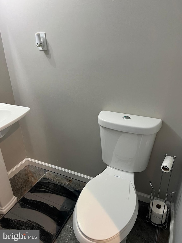 bathroom with toilet and tile patterned flooring