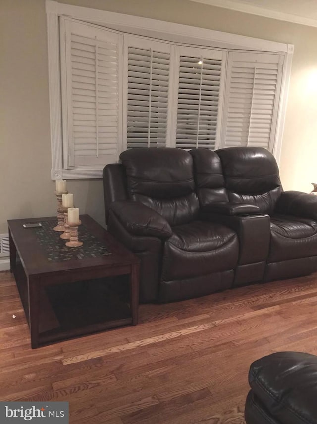 living room with dark wood-type flooring and ornamental molding