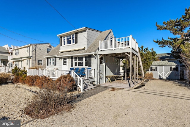 back of house featuring a storage shed and a wooden deck