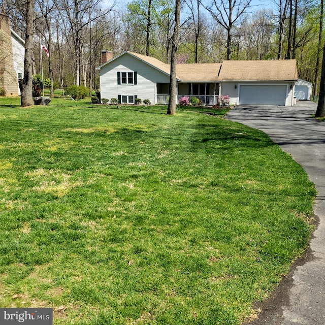 single story home with a porch, a garage, and a front yard