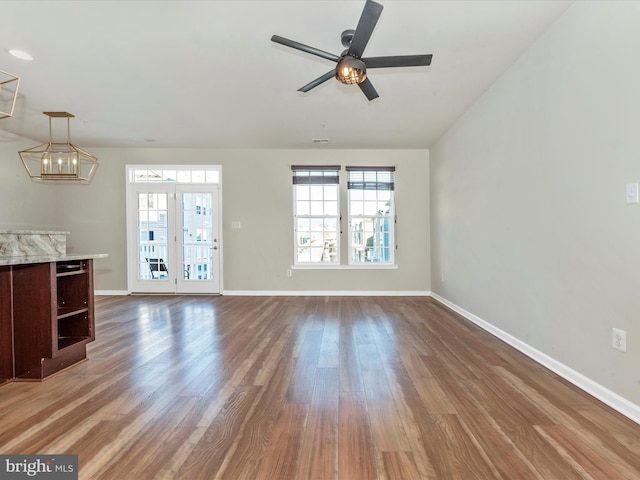 unfurnished living room featuring ceiling fan and dark hardwood / wood-style flooring