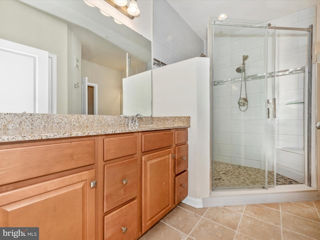 bathroom featuring tile patterned flooring, an enclosed shower, and vanity