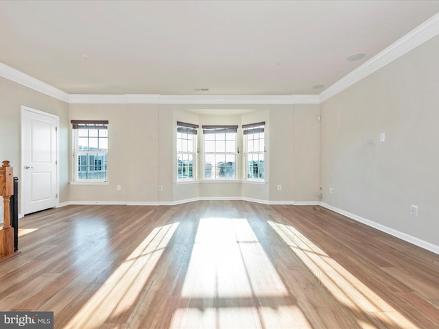 empty room with crown molding and hardwood / wood-style flooring