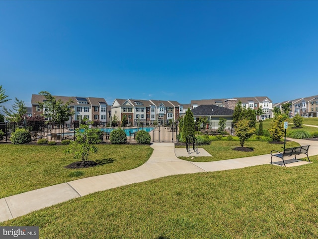 view of home's community featuring a pool and a lawn