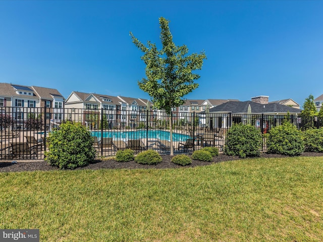 view of swimming pool with a yard