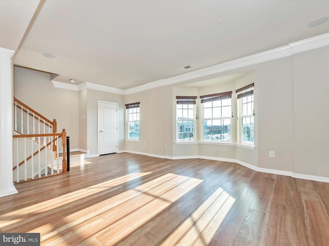 empty room with crown molding and wood-type flooring