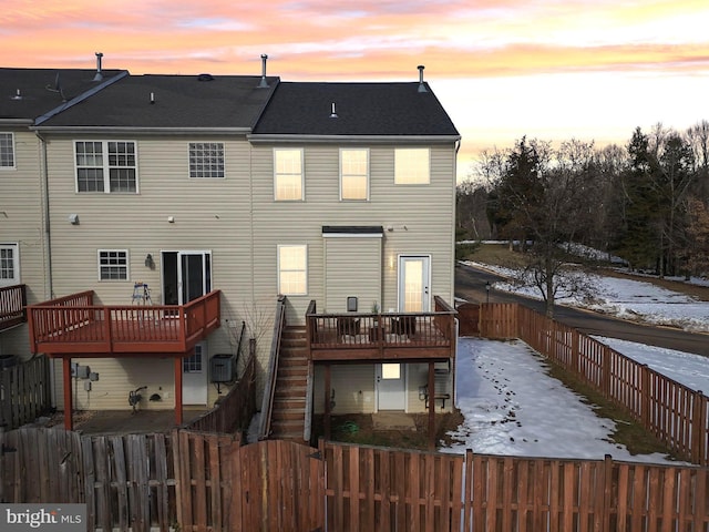 snow covered property with a deck and central AC unit