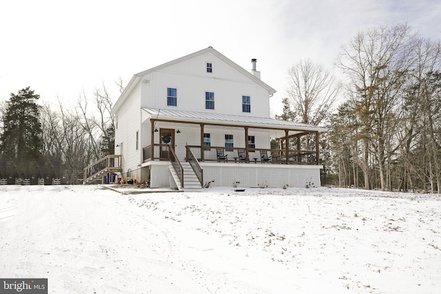 snow covered property with covered porch