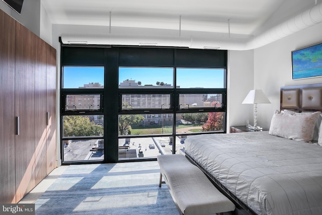 bedroom featuring wooden walls and multiple windows