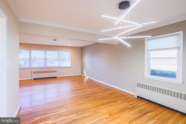 unfurnished room with radiator, ornamental molding, and light wood-type flooring