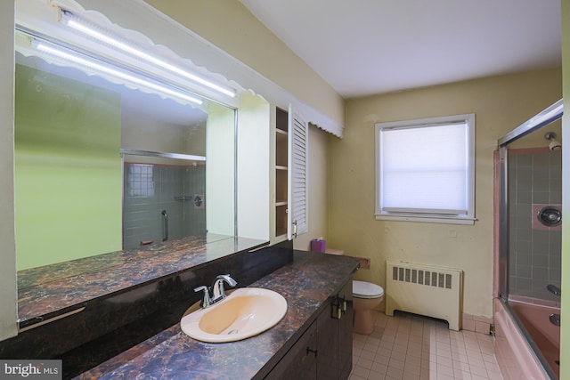 full bathroom featuring radiator, shower / bath combination with glass door, vanity, toilet, and tile patterned floors