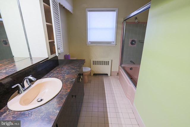 full bathroom with radiator, tile patterned flooring, vanity, enclosed tub / shower combo, and toilet