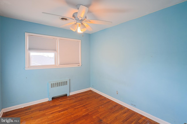 spare room with ceiling fan, radiator heating unit, and hardwood / wood-style floors