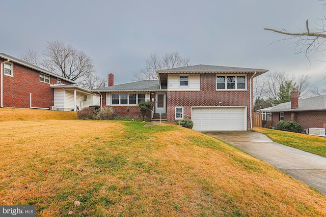 tri-level home with a garage and a front lawn