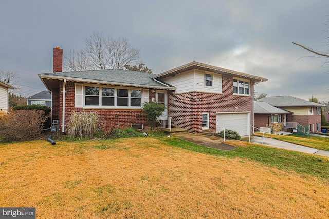 split level home featuring a garage and a front lawn