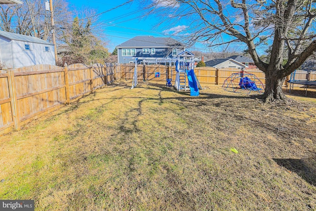 view of yard featuring a trampoline and a playground