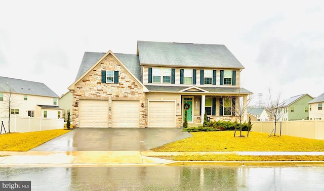 view of front of house with a garage, a front yard, and covered porch