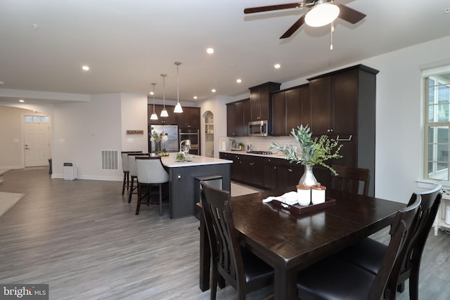 dining area featuring ceiling fan, sink, and light hardwood / wood-style floors