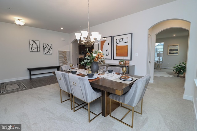 dining room with light colored carpet and a chandelier