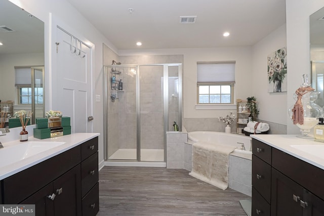 bathroom with hardwood / wood-style flooring, vanity, and shower with separate bathtub