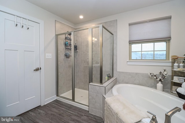 bathroom with hardwood / wood-style flooring and shower with separate bathtub