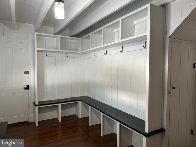 mudroom featuring beam ceiling and dark wood-type flooring